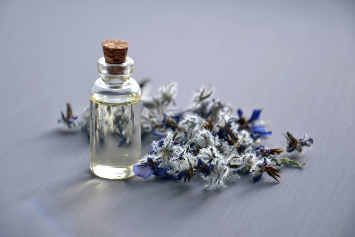 perfume bottles with small flowers next to it