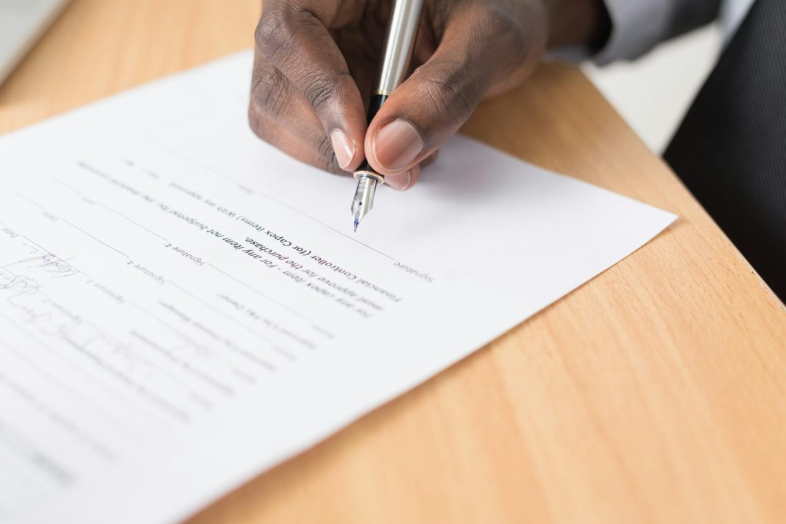 person writing on paper about business contract dispute