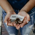 person showing both hands with make a change note and coins