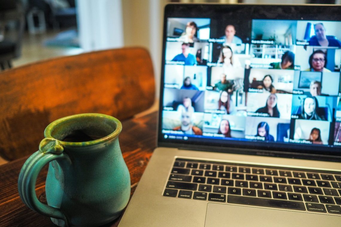 macbook pro displaying group of people; Manage Remote Teams