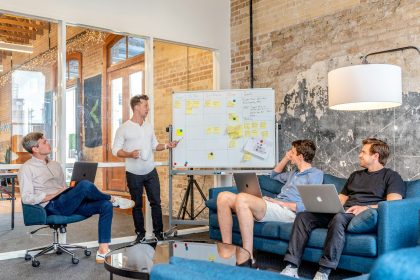 three men sitting while using laptops and watching man beside whiteboard; confident founder lessons