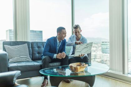 two men in suit sitting on sofa; scale as young entrepreneur