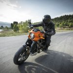 person driving orange motorcycle; young entrepreneurs rethinking commute