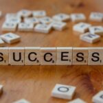 Scrabble tiles spelling out the word success on a wooden table; success feels emptier