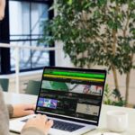 A man sitting at a desk using a laptop computer; become successful