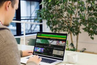 A man sitting at a desk using a laptop computer; become successful