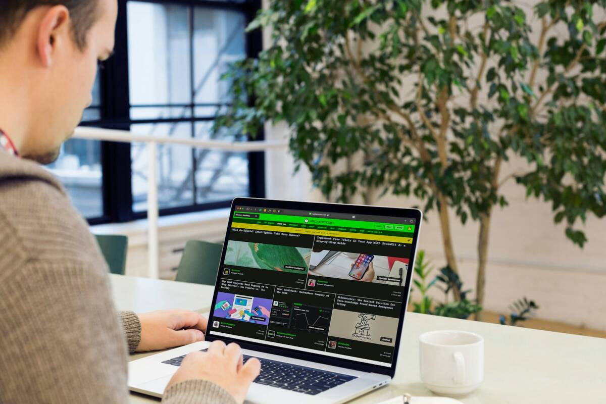 A man sitting at a desk using a laptop computer; become successful