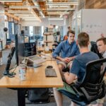 Entrepreneurs sitting in open workspace discussing strategy; entrepreneurial mindset corporate burnout