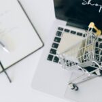 Creative depiction of online shopping with a miniature cart on a laptop keyboard; omnichannel retail