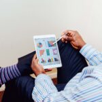 Businessman using a tablet for data analysis in a relaxed office setting; ai roi