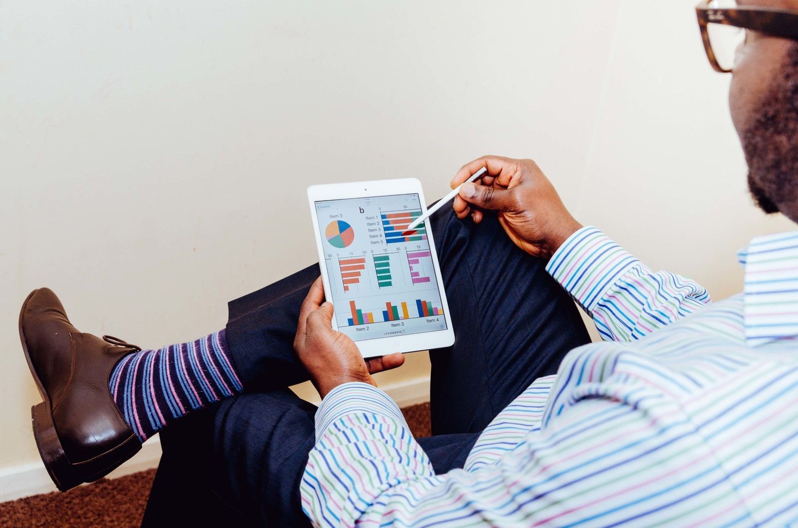Businessman using a tablet for data analysis in a relaxed office setting; ai roi