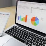 Laptop displaying charts and graphs with tablet calendar for data analysis and planning; small business automation
