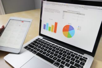 Laptop displaying charts and graphs with tablet calendar for data analysis and planning; small business automation