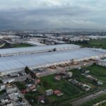 Aerial view of industrial warehouses in Mexico City surrounded by residential areas and greenery; flexible warehouse space