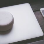 A smart speaker, laptop, and smartphone array representing modern technology lifestyle on a wooden surface; ai voice models