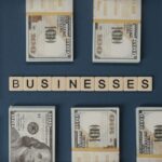 Bundles of US hundred-dollar bills and Scrabble tiles spelling