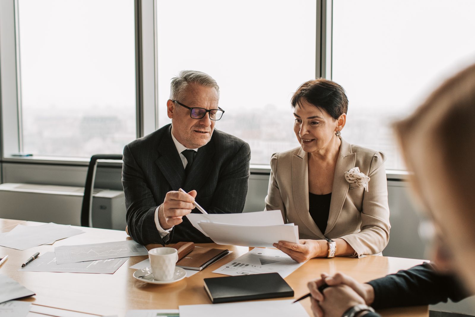 Dirigeant réunissant son conseil consultatif autour d'une table pour examiner des documents confidentiels